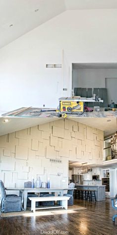 the inside of a kitchen and dining room with hard wood flooring on the walls