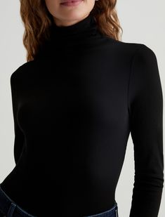 The Chels Turtleneck for women features true black hue, classic fold-over neck, extended sleeves with raw edges, and form-fitting silhouette. This women’s top is designed in2x1 Lyocell Rib fabrication, offering comfort and luxury in a wider rib construction.    2x1 Lyocell Rib, 96% Lyocell, 4% Spandex/Elastane Black Second-skin Tops For Workwear, Black Funnel Neck Top In Elastane, Black Turtle Neck, Selvage Denim, Ag Jeans, Black Turtleneck, Outerwear Sweater, Denim Top, Sweater Accessories