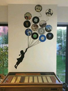 a wooden table topped with an old record player and a wall hanging on the wall