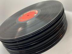 a stack of black records sitting on top of a white table