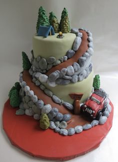 a birthday cake made to look like a train track with trees and rocks on top