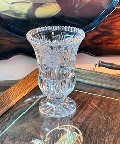 a glass vase sitting on top of a wooden table