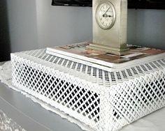 a white wicker table with a clock on top