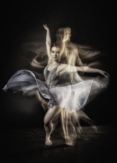 two ballet dancers in motion on a black background