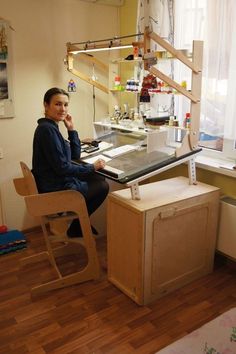 a woman sitting at a desk in front of a window