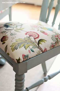 an upholstered chair with a floral seat pad on the bottom and back rest