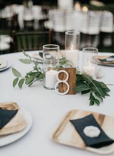 the table is set with candles, plates and napkins