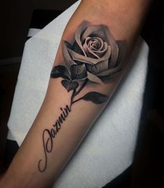 a black and white rose tattoo with the word damn written in cursive font