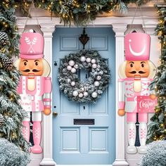 two nutcrackers standing in front of a blue door decorated with christmas decorations