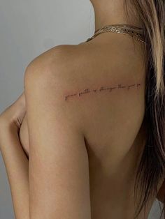 the back of a woman's shoulder with writing on it