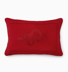 a red pillow with a snake embroidered on it