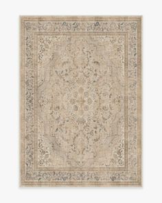 a beige rug with an intricate design on the middle and bottom, in various colors