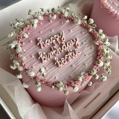 a pink birthday cake in a box with white flowers on it that says happy birthday bernie