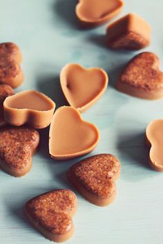 some heart shaped cookies sitting on top of a blue table with peanut butter in the middle