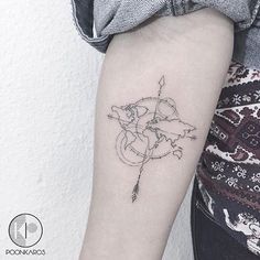 a woman's arm with a small arrow and map tattoo on the left forearm