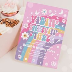 a pink box filled with cupcakes next to a card that says groozy one