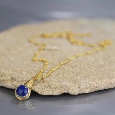 This unique small pendant necklace features a stunning cabochon lapis set in silver bezel on a gold filled chain. Delicate wire wrapping encircles the pendant and connects between the chain and pendant. This pendant necklace is delicate yet unique and eye catching! Materials: Stone: Dainty Lapis Lazuli Jewelry For Gift, Dainty Lapis Lazuli Jewelry Gift, Gold Lapis Lazuli Jewelry With Cabochon, Gold Lapis Lazuli Cabochon Jewelry, Sterling Silver Yellow Gold Wire Wrapped Necklaces, Nickel Free Lapis Lazuli Necklace For Gift, Lapis Lazuli Round Pendant Necklace Gift, Nickel-free Lapis Lazuli Necklace Gift, Yellow Gold Lapis Lazuli Necklace For Gift