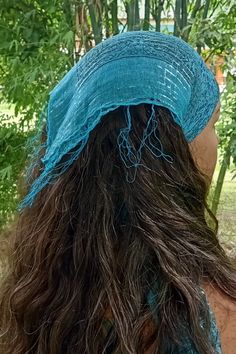 the back of a woman's head with long hair and a blue hat on