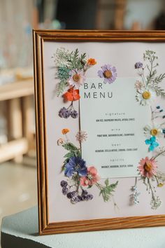 a framed menu with colorful flowers on it