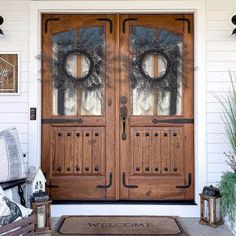 the front door is decorated with wreaths and lanterns