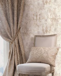 a chair sitting in front of a window next to a wall with curtains on it