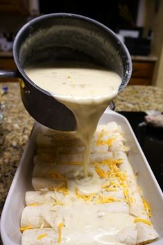 someone pours cheese sauce on top of quesadillas in a baking dish