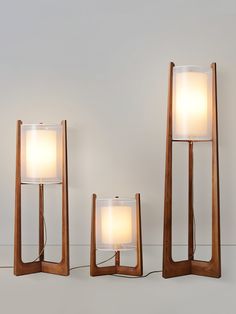 three wooden lamps with one light turned on and the other turned off, sitting next to each other