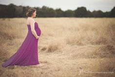 a pregnant woman is standing in a field