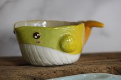 a yellow and white bowl sitting on top of a wooden table