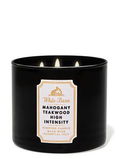 a black candle that is sitting on a white surface with the words, mahogany and tealight