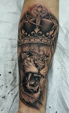 a man's leg with a lion and crown tattoo on it