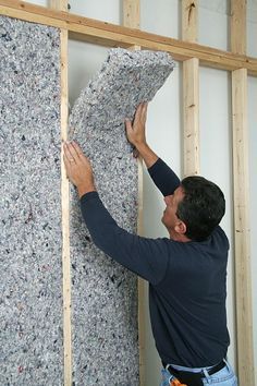 a man working on a wall in a room under construction