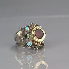 A magenta cubic zirconia ring made for a queen!It is ornate but delicate, statement piece but not oversize.The band is adjustable to any finger size and made of sterling silver set with natural turquoise gemstone and green cubic zirconia. The center is a bezel set faceted cubic zirconia and 9K solid gold, welded on sterling silver, which is hammered.You will feel like royalty when wearing it!Measurements: Center stone - 10mm Size:This queen ring is adjustable to any size, it has a small open so Hammered Metal Jewelry, Silver Gold Ring, Queen Rings, Antique Style Rings, Accesories Jewelry, Aesthetic Jewelry, Gold Gemstone Ring, Gold And Silver Rings, Dope Jewelry