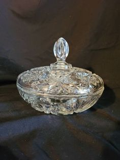 a clear glass bowl with a crystal knob on the top and an ornate design in the bottom