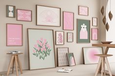 there are many framed pictures on the wall in this room, including pink and green