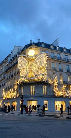 people are walking around in front of a building decorated with christmas lights and fairy decorations