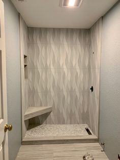 a walk in shower sitting next to a white door