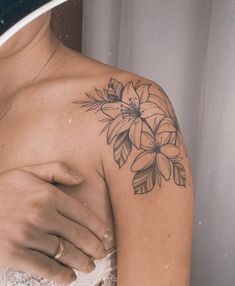 a woman's arm with a flower tattoo on her left shoulder and right arm