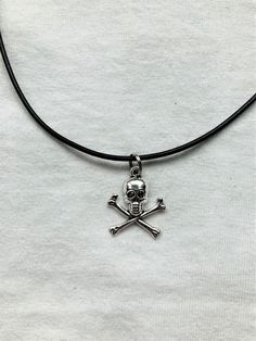 Skull and Bones pendent with a leather cord style necklace. The necklace is 12 and a half inches long but has a 2 inch extender at the end so you can adjust the size. Any questions don't hesitate to drop me a message. Emo Metal Choker As Gift, Black Skull Jewelry Grunge Style, Skull Choker, Rock Pendant Necklace, Black Nickel Free Skull Necklace, Black Skull Shaped Grunge Jewelry, Nickel Free Black Skull Necklace, Black Skull Necklace In Edgy Style, Black Skull Grunge Jewelry