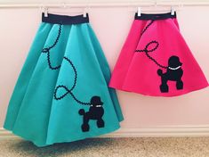 two skirts with poodles on them hanging from hooks