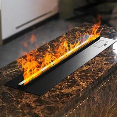 an electronic device with flames on it sitting on top of a marble table in the middle of a room