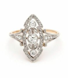 an antique diamond ring with three stones on the side and two rows of diamonds in the middle