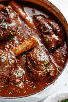 a pot filled with meat and sauce on top of a table