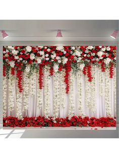 an arrangement of red and white flowers on a wall with drapes for the backdrop