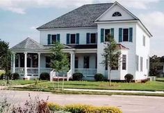 a large white house sitting on the side of a road