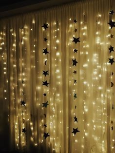 the curtain is decorated with stars and moon lights in gold, black and white colors