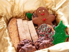 some cookies and other food items are in a tin foil container with gold wrapping around them