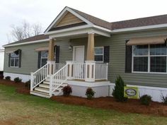 a mobile home with stairs leading up to the front door and steps down to the second floor