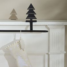 a christmas stocking hanging from a coat rack in front of a fireplace with a tree on it