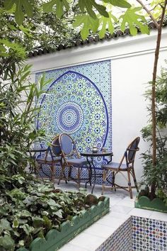 an outdoor dining area with blue and white tiles on the wall